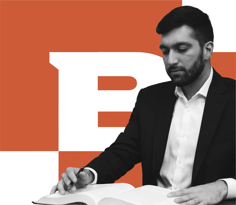 Man reading book with the brck logo behind him